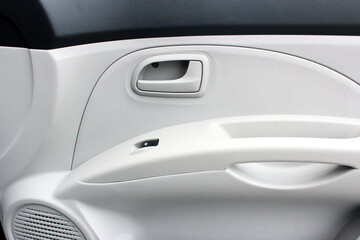 Car Inside Door Handle Interior. Door trim. Window lifters control. Side Window Switch. Beige Car Interior. Clean door trim and soft touch panel. Light car interior.