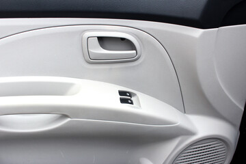 Obraz na płótnie Canvas Car Inside Door Handle Interior. Door trim. Window lifters control. Side Window Switch. Beige Car Interior. Clean door trim and soft touch panel. Light car interior.