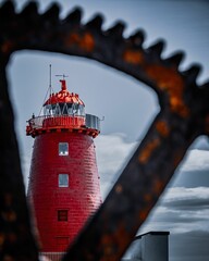 Lighthouse on a pier in the sea seen through a cog