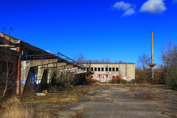 Fototapeta na wymiar Factory ruins with smokestack on a sunny day in Germany