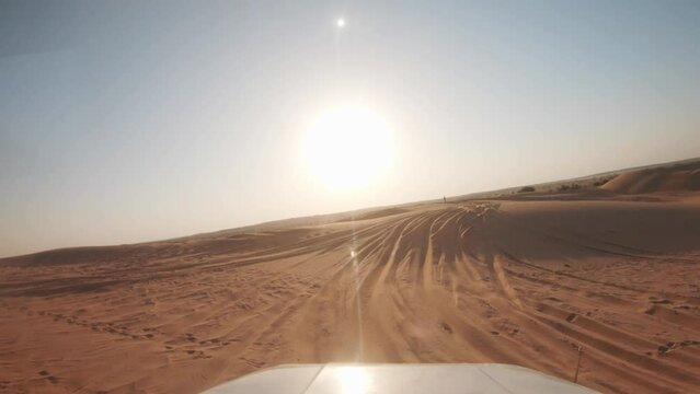 4K POV of a vehicle dune bashing on the sand dunes of the Thar desert at Jaisalmer in Rajasthan, India. Car moves on the desert during the day. Extreme adventure in the desert background.