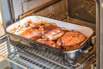 Real hearty homemade roast pork is cut into portions on a wooden board in the kitchen, Germany