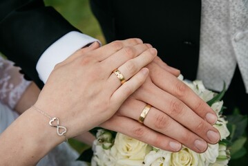 Obraz na płótnie Canvas Closeup of bride and groom's hands on each other after putting on the marriage rings