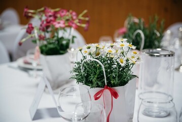 Flower decoration with glass cups on a table of wedding hall