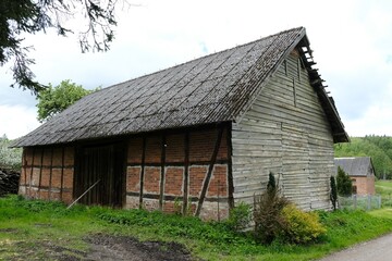 Fototapeta na wymiar A barn with half-timbered construction in summer scenery on kashubian village, around Bytow, Poland