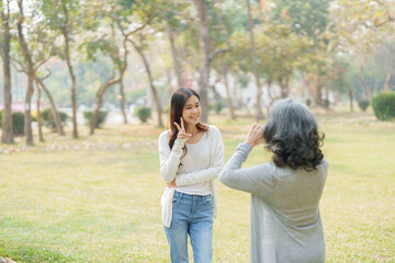 Asian teenage mother and daughter walking in park with camera to capture memories