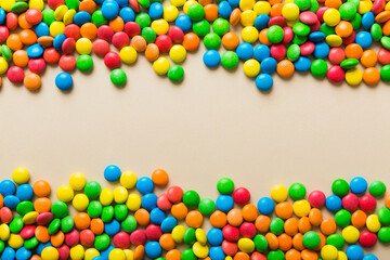Obraz premium Mixed collection of colorful candy, on colored background. Flat lay, top view. frame of colorful chocolate coated candy