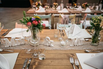 Selective focus of the glass cups, and decorations on a wooden table at wedding party