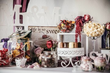 Candy jars and snacks with wedding decorations on the table