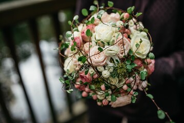 Closeup shot of a person holding a beautiful white green bouquet
