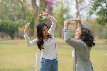 Grown daughter with aging mother showing love and walking together in the parkland