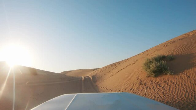 4K POV of a vehicle dune bashing on the sand dunes of the Thar desert at Jaisalmer in Rajasthan, India. Car moves on the desert during the day. Extreme adventure in the desert background.
