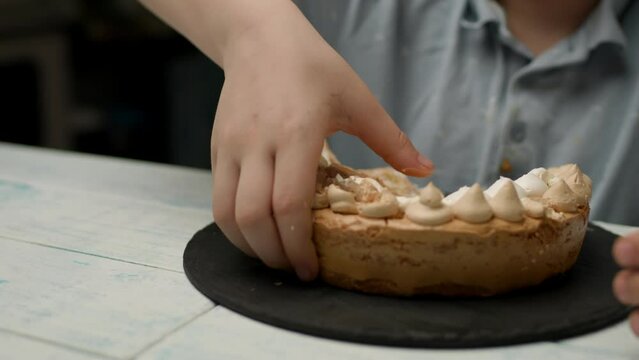 Dirty Kid Eating Cake With Hands. Happy boy eating sweets. Slow motion, handheld camera.