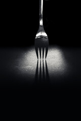 Silberne Gabel im Lichtschein wirft Schatten