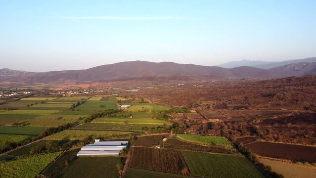 aerial view of farmland and mountains at sunrise