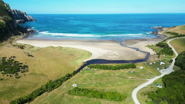 Picturesque campsite on wonderful ocean beach, aerial backwards ascending