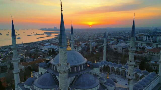 Aerial drone view of Istanbul at sunset, Turkey. The Blue Mosque, with gardens and buildings around, Bosporus strait with ships