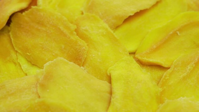 Mango Slices, Macro. Ripe Slices Of Dried Mango, Close-Up, Spin, Top View. Isolated Frash Mango Pieces. Background of Yellow Mango Slices. Healthy Food, Vegetarian Vitamin Diet.