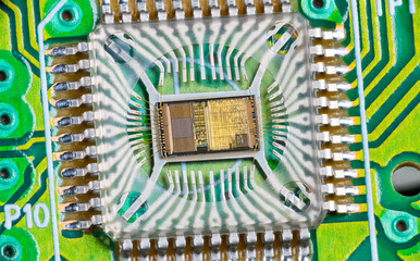 Closeup of electronic integrated circuit die with photodiode array and gold wires on green PCB....