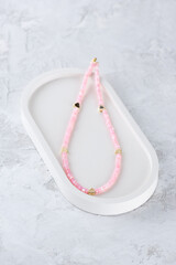 Beads or choker made of pink mother-of-pearl beads with golden hearts.
