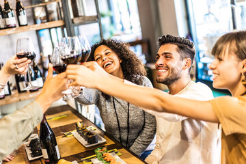 Multiethnic friends toasting red wine at sushi restaurant - Food and beverage lifestyle concept...