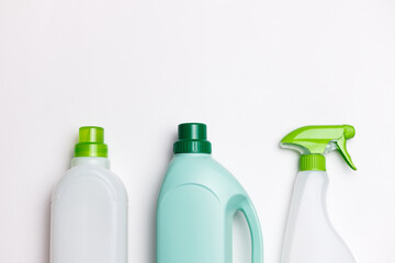 Set of three detergent bottles with green caps and spray head on white background. Top half on pic