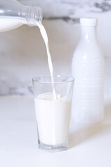 A glass of milk is poured into a glass.