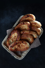 Bread cakes in a basket on a black background.lat lay. Top view. Copy space.