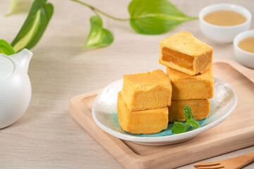 Delicious pineapple cake pastry in a plate on wooden table background with tea.
