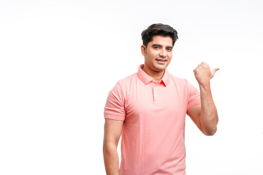Young indian man indicating finger to empty space.