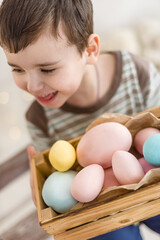 Fototapeta na wymiar Easter eggs in a basket are held by a little boy.