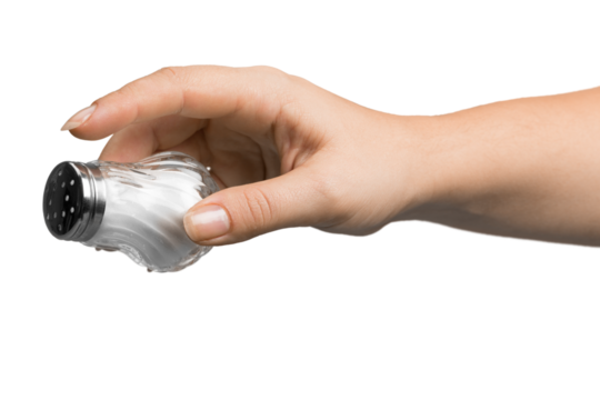 Female hand pouring salt from salt shaker on white background
