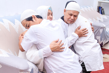 Parents and son hugging and forgive each other at eid moment. 