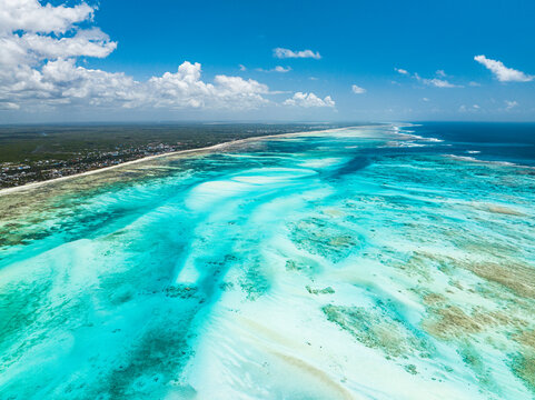 Aerial view of white coral sand of a blue lagoon at low tide, Paje, Jambiani, Zanzibar, Tanzania