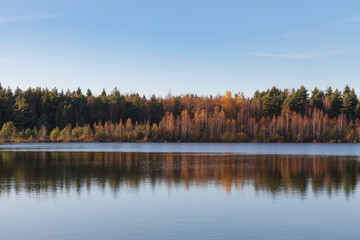 Fototapeta premium Fall colours of forest reflected in the waters of a lake