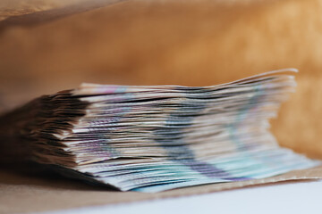 Macro shot of stack of money in paper bag. Corruption, bribe concept