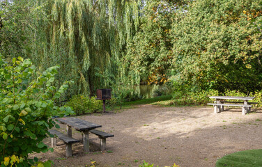 Barbecue area in the park with a grill and wooden tables. High quality photo