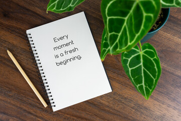 Short inspirational quotes text on note pad - Every moment is a fresh beginning