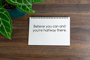 Short inspirational quotes text on note pad - Believe you can and you're halfway there.
