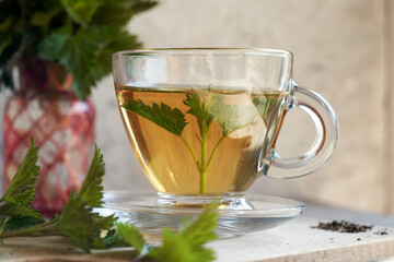 A cup of herbal tea with fresh nettles