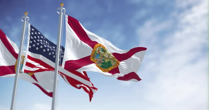 Seamless loop in slow motion Florida and United States flags waving