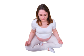 Pregnant woman in the lotus position on the couch in the living room, isolated on a white background