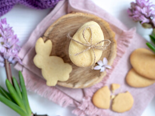 Easter cookies in the form of eggs and rabbits, flowers nearby