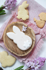 Easter cookies in the form of eggs and rabbits, flowers nearby