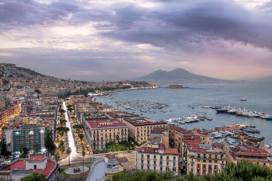 View of Naples downtown at sunset with Vesuvius volcano in background, Campania, Italy.