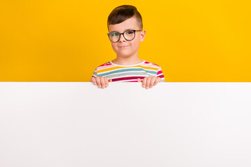 Photo of nice man wear striped trendy clothes stand behind empty space presenting promo isolated on yellow color background
