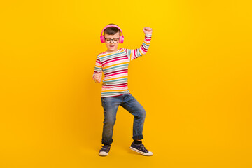 Full length photo of crazy boy wear stylish clothes celebrate sale discount listen mp3 empty space isolated on yellow color background