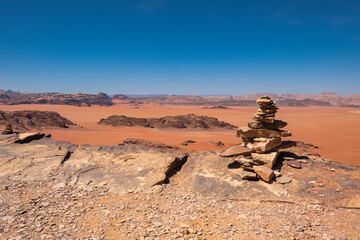 Wadi Rum red desert with some stone stacked in a pile in the foreground, Jordan, Middle East