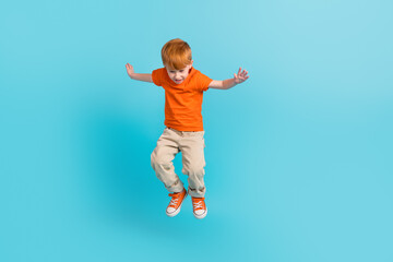 Obraz premium Full length photo of cheerful crazy boy wear orange trendy clothes look down celebrate sale isolated on cyan color background