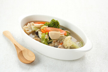 Capcay, stir fried vegetables with shrimp, meatballs and chicken. Served in white plate
